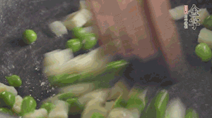 鍋中油7成熱時，入青豆、筍丁翻炒，然后加糯米飯加鹽均勻翻炒。