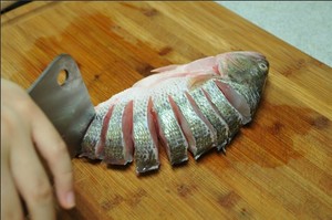 將鱸魚清洗干凈，從脊椎處切斷至腹部，腹部保留1cm左右不要切斷。