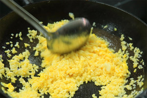 大火加熱炒鍋，再入油，燒到四至五成熱時倒入雞蛋液，在未凝結(jié)之前，加米飯煸炒，不停翻炒并用鍋鏟將成塊的米飯碾開、撥散。