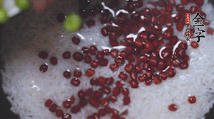 將炒好的食材和大米、紅豆一起放進(jìn)電飯鍋煮。