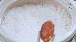 煮開后轉(zhuǎn)小火，當米飯出現(xiàn)小孔時，鋪上金字麻辣香腸。