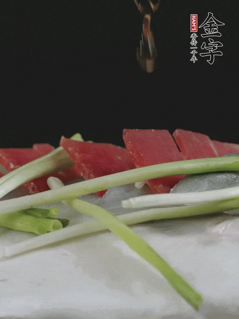 蔥白置于魚(yú)身，放適量豌豆，淋上花雕酒。