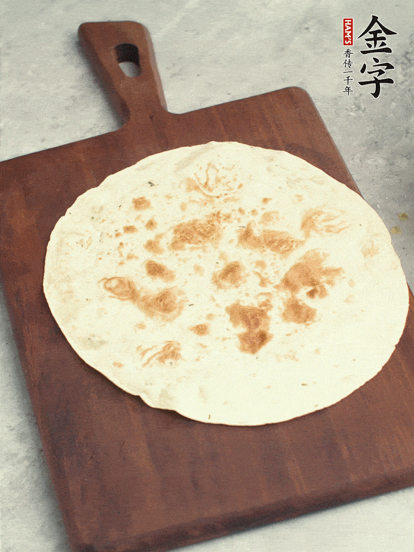 食材依次鋪在卷餅皮上，卷起來。