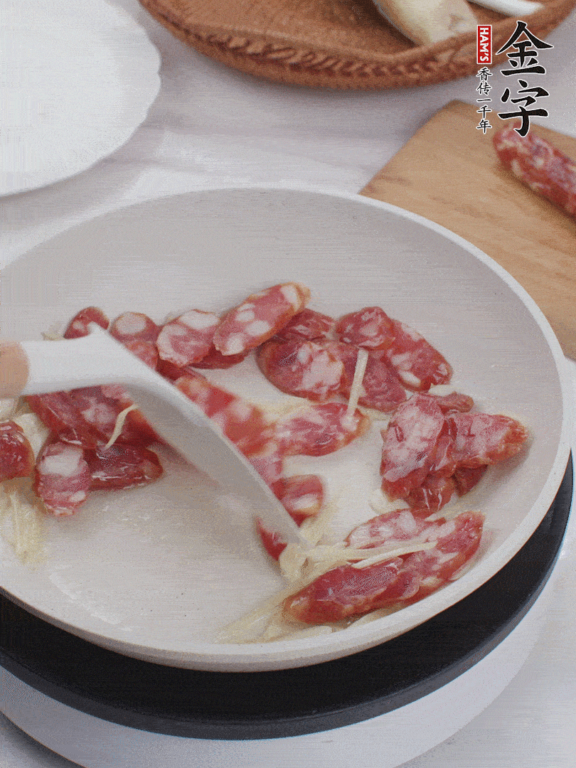 油溫3成熱時，下姜絲、蒜片、香腸炒出油脂。