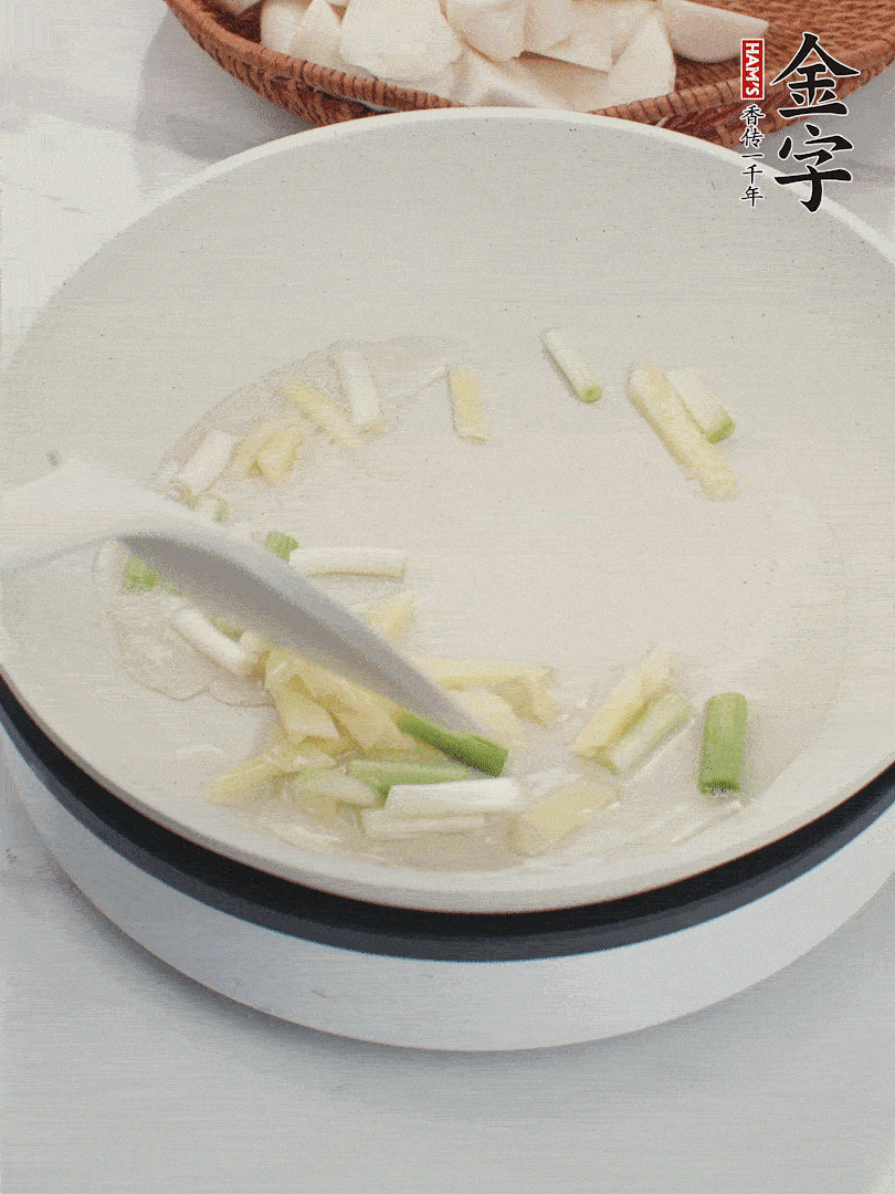 鍋中油五成熱，下蔥白、姜片爆香。