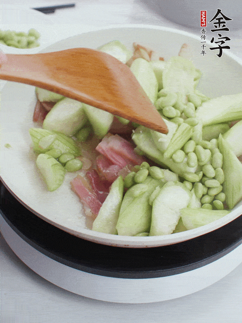 依次下絲瓜、青豆翻炒，炒至絲瓜打蔫縮小。