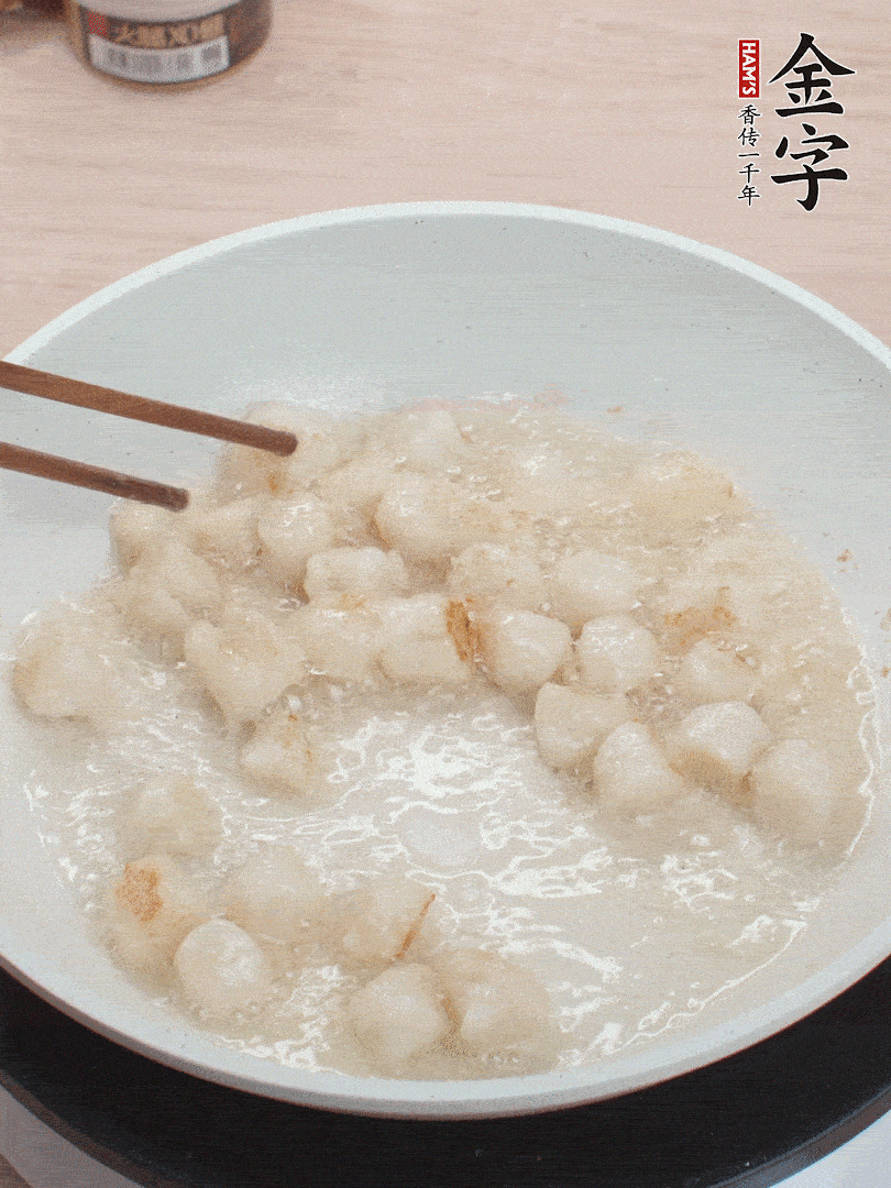 油溫4成熱，鮮貝蘸干淀粉下鍋煎，一面微黃后翻面。