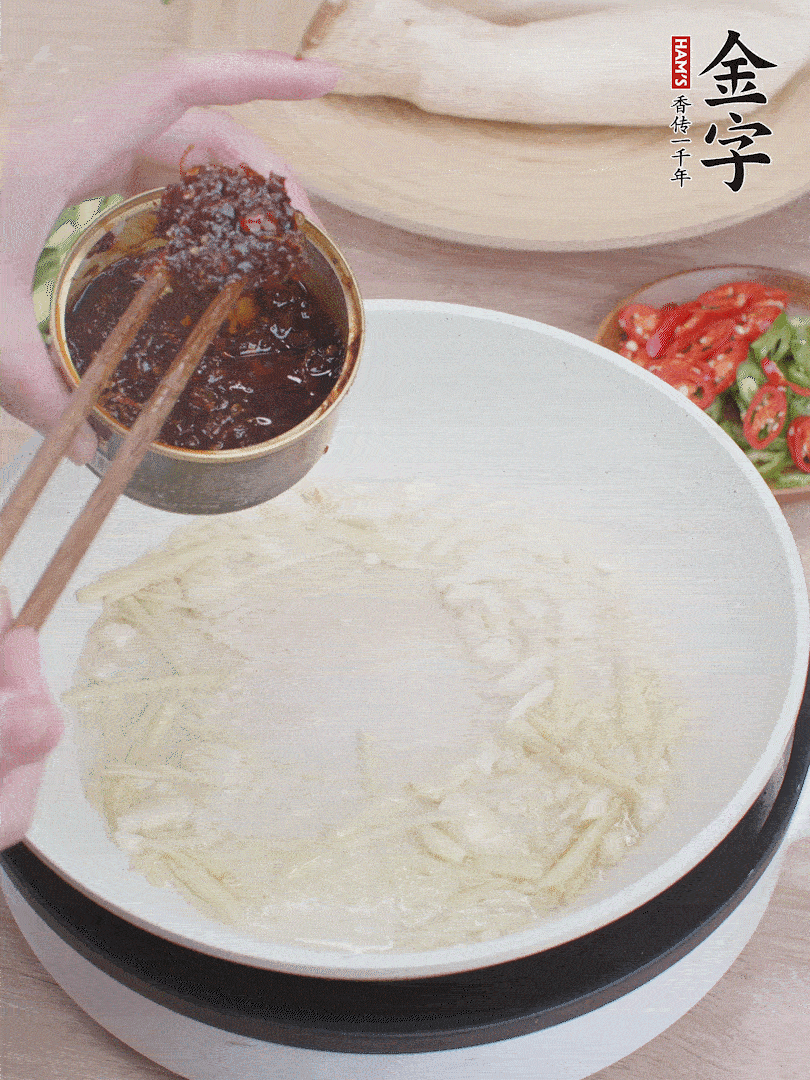 起鍋熱油，姜蒜、金字火腿干貝醬煸香。