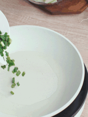 熱油下臘肉、蔥花煸炒，再下西葫蘆。