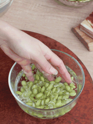 青豆剝殼，搓去外衣。