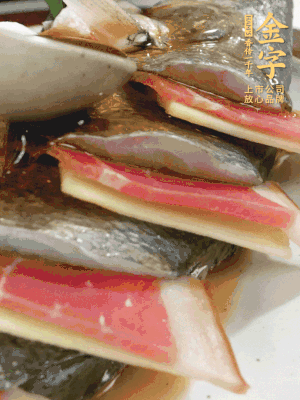 魚肚中塞蔥結(jié)、火腿片，魚身上碼放姜片、火腿片，倒入混合的料汁。