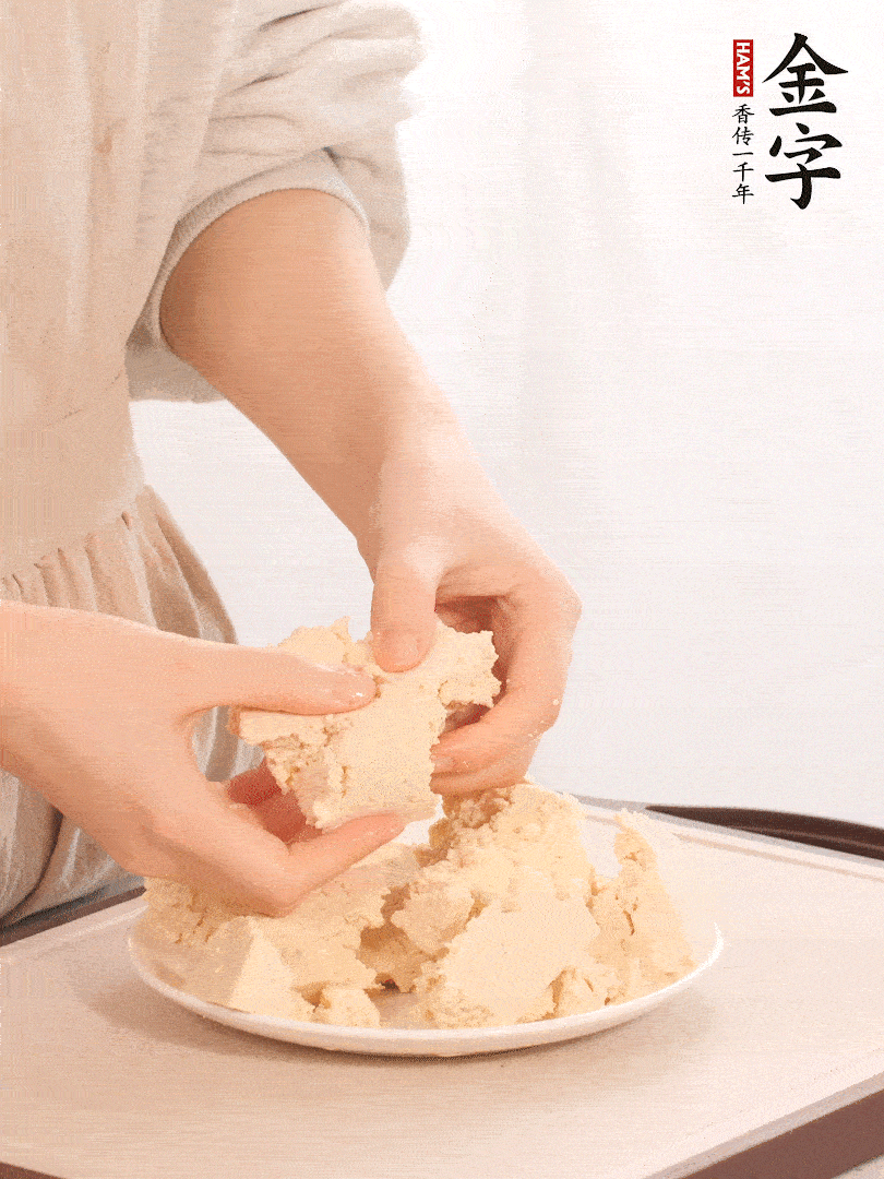 老豆腐用手掰成塊。