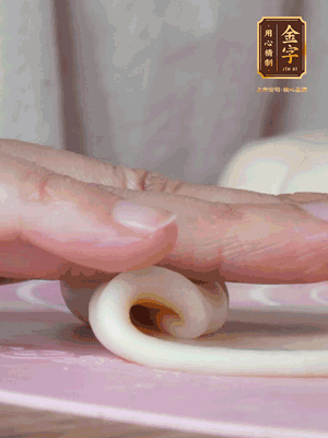 做面劑 油皮按扁，中間包入一個油酥，邊緣收緊捏死。包好的面劑按扁，用搟面杖搟壓成橢圓形。從底部向上卷成筒狀，用保鮮膜蓋好松弛15分鐘，再把筒狀縱向搟壓成長條狀。再卷一次，松弛20分鐘