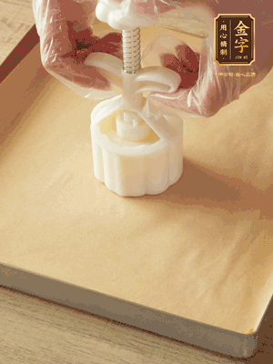 取一個面團，捏扁，中間厚，四周薄。虎口往上推，直到收口，把餅胚放入模具里，壓2-3下