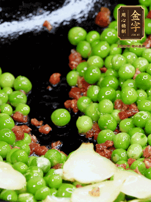 鍋內(nèi)少許油，下火腿煸香，再下甜豆米、百合翻炒，少許鹽、一點(diǎn)水煮到收干