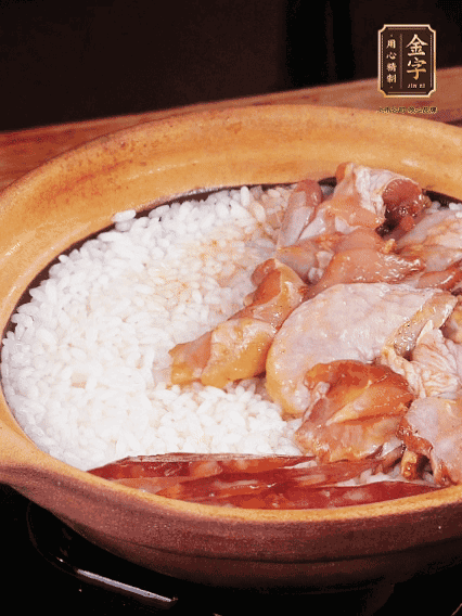 煮到椰子水微微收干轉(zhuǎn)小火，快速均勻鋪上雞肉、金字香腸